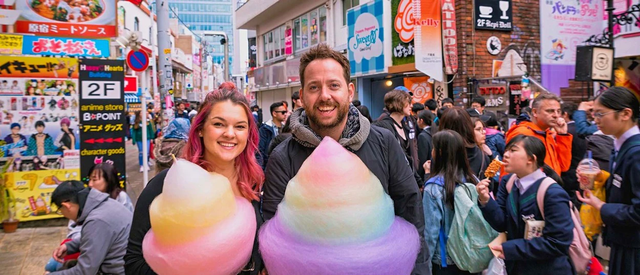 Couple holding giant rainbow candy floss on Harajuku's Takeshita Street