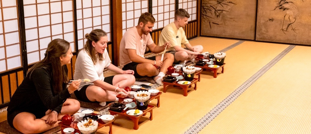 Group kneeling on tatami mats for the monks' traditional dinner