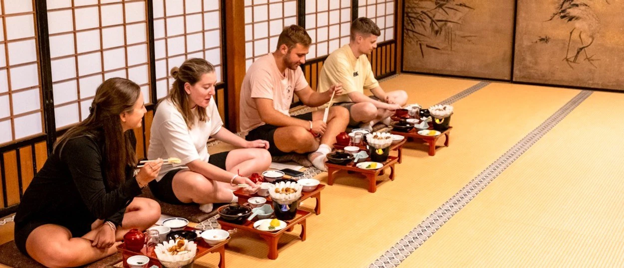 Group kneeling on tatami mats for the monks' traditional dinner