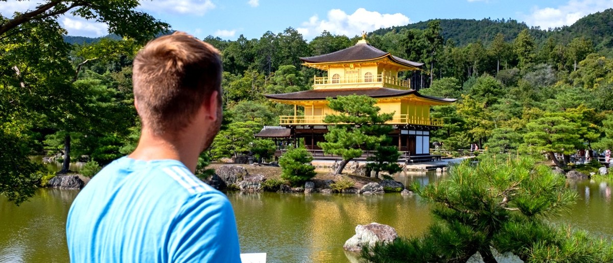 Traveller looking across the water to Kyoto's Golden Pavilion