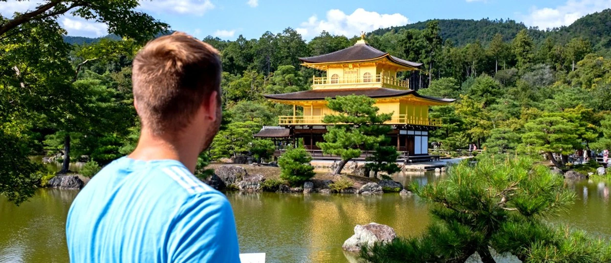 Traveller looking across the water to Kyoto's Golden Pavilion