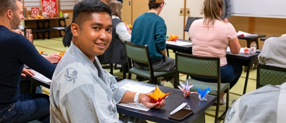 Traveller folding origami paper during a class in Nagano