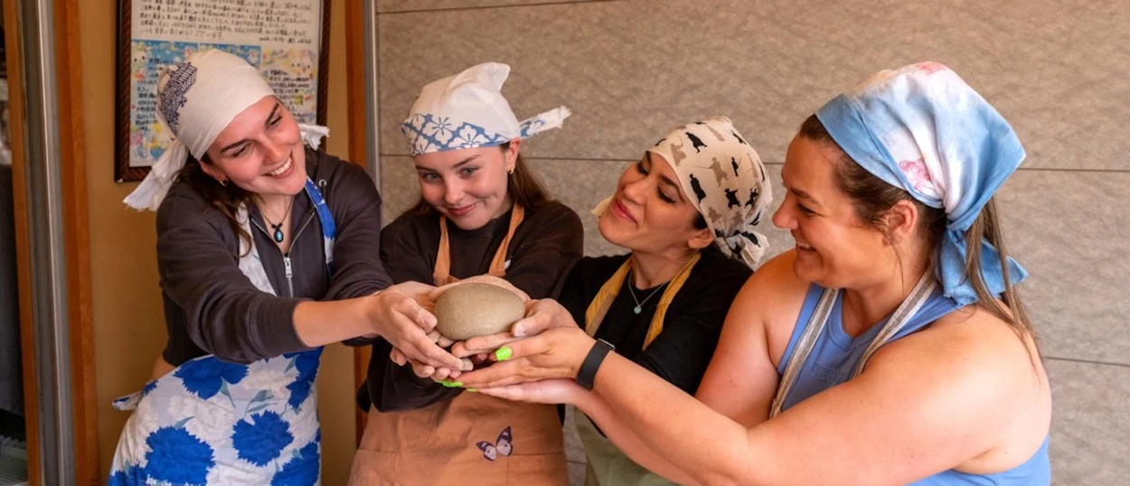 Travellers in headscarves shaping soba dough in a Nagano cooking class