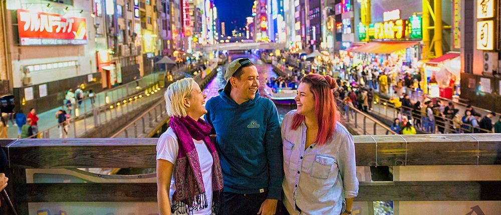 Travellers taking in the neon of Osaka's Dotonbori canal