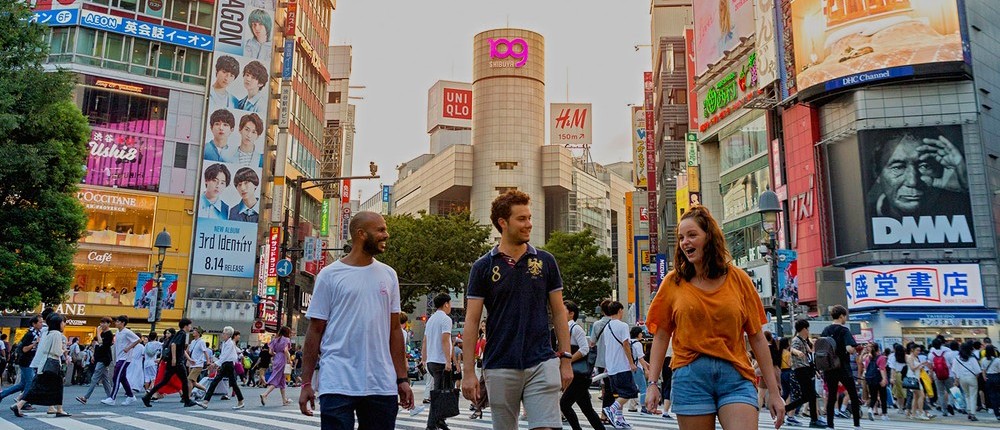 Travellers walking across the world's busiest intersection in Shibuya
