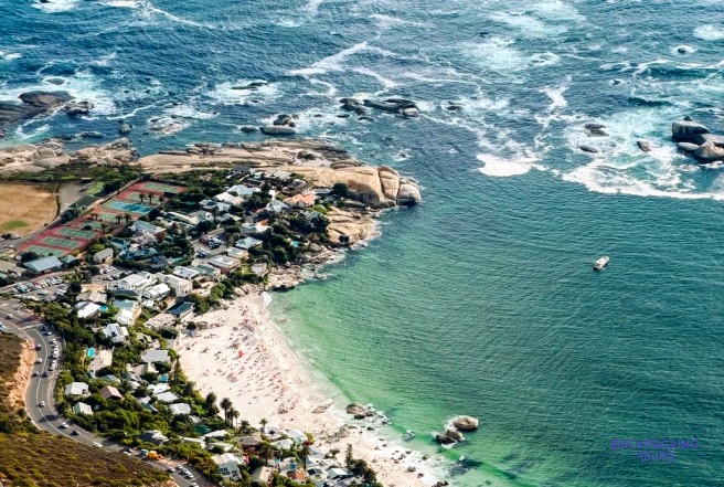 Bird's-eye view of a coastal suburb, a white sand beach and turquoise sea