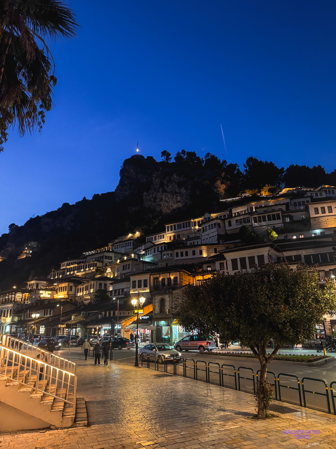 Rows of lit Ottoman houses stacked up the hillside of Berat's Mangalem quarter at night