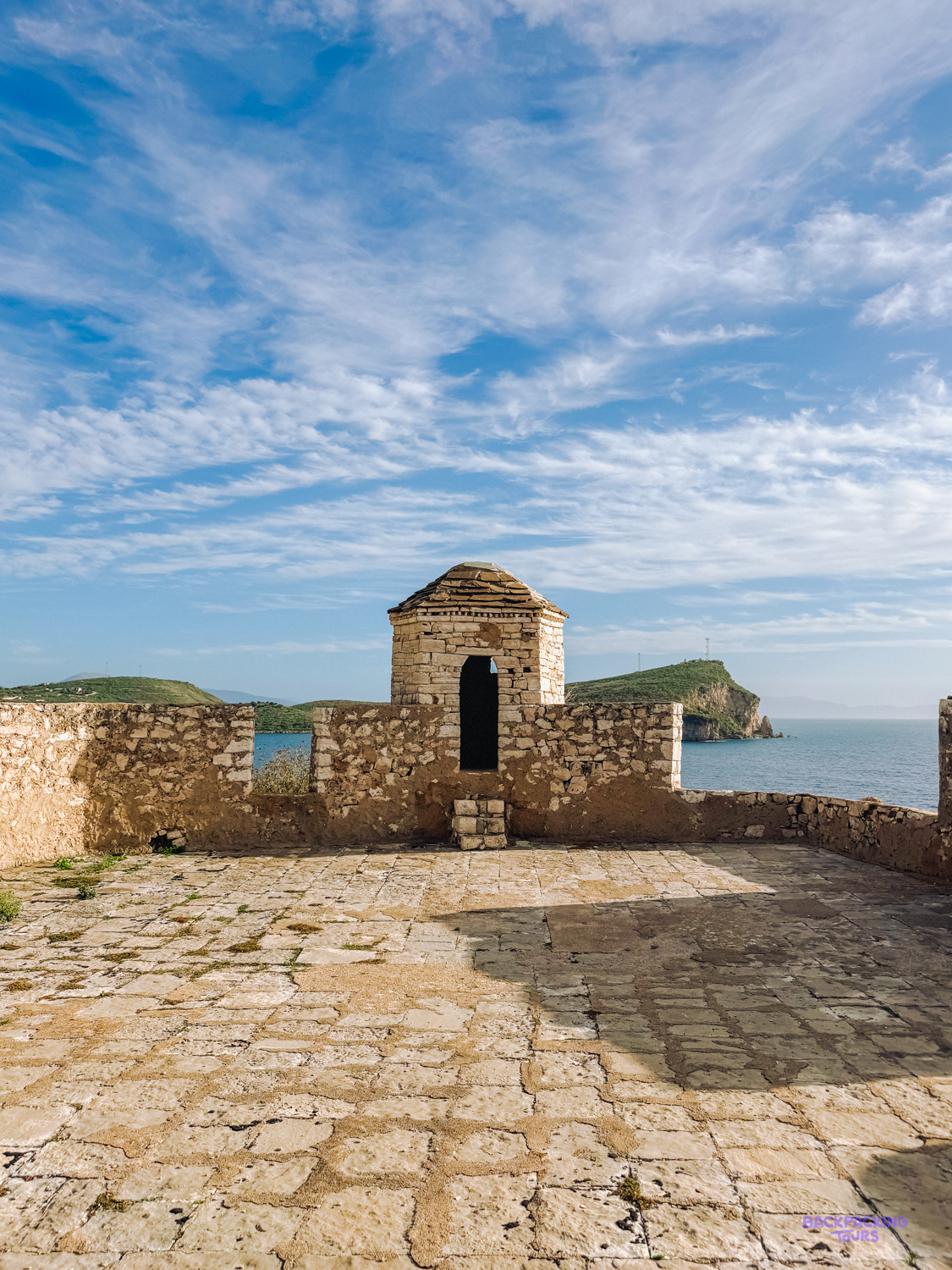 Stone ramparts and a small watchtower of Porto Palermo Castle looking out to sea