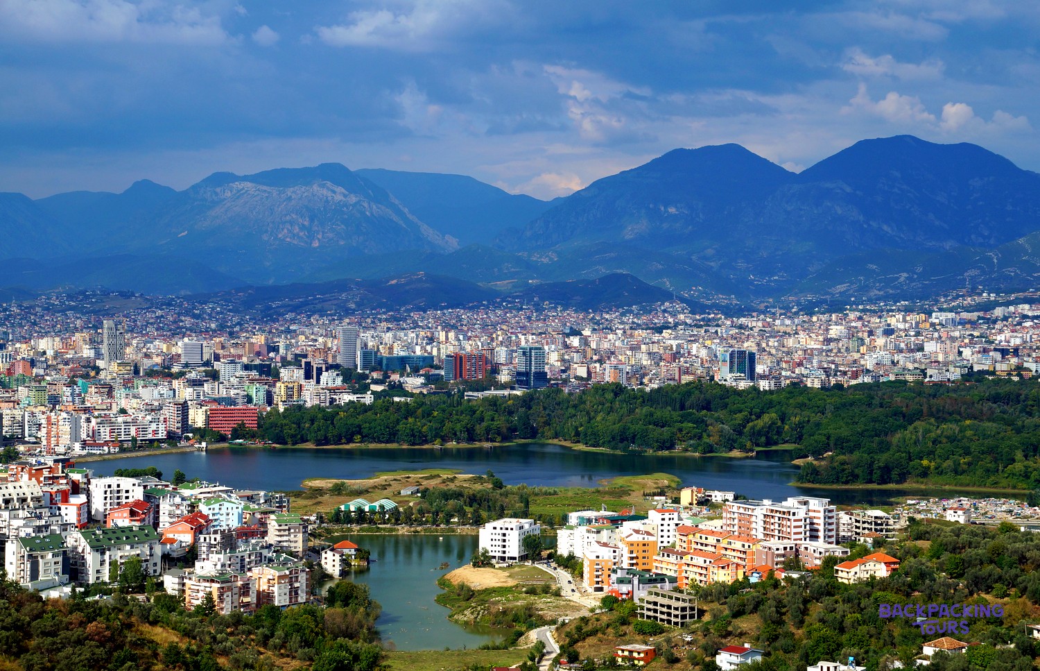 Tirana spread out below the mountains, with the Grand Park lake in the foreground