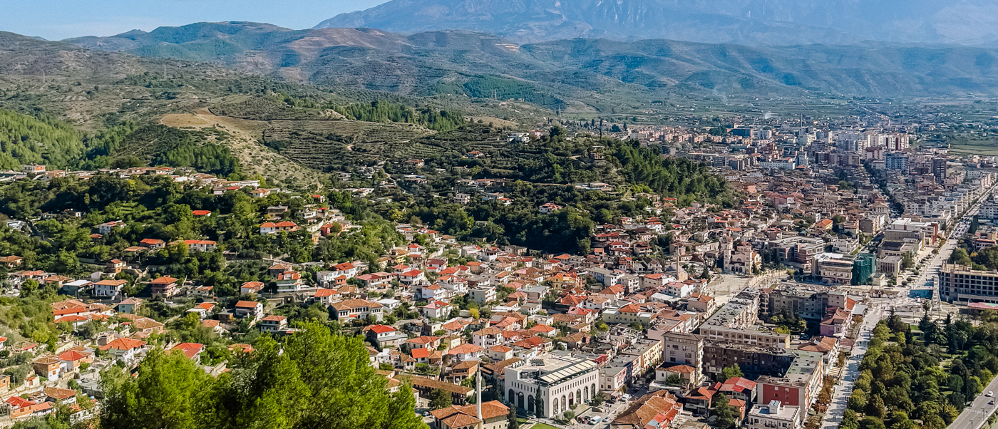 View from the castle hill over Berat's red roofs and the valley towards distant mountains