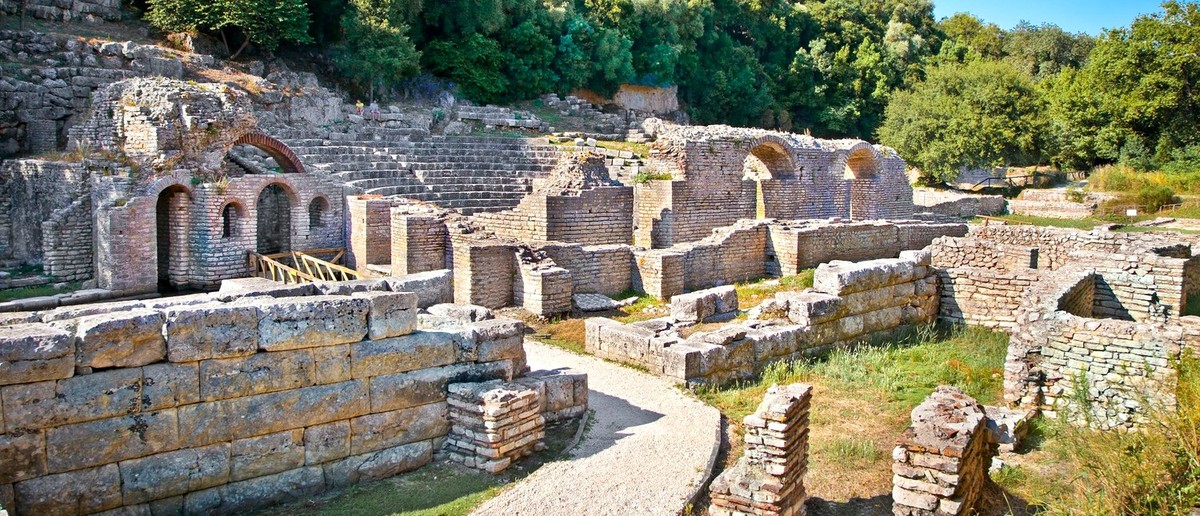 Ancient stone walls and arches among the trees at Butrint Archaeological Park