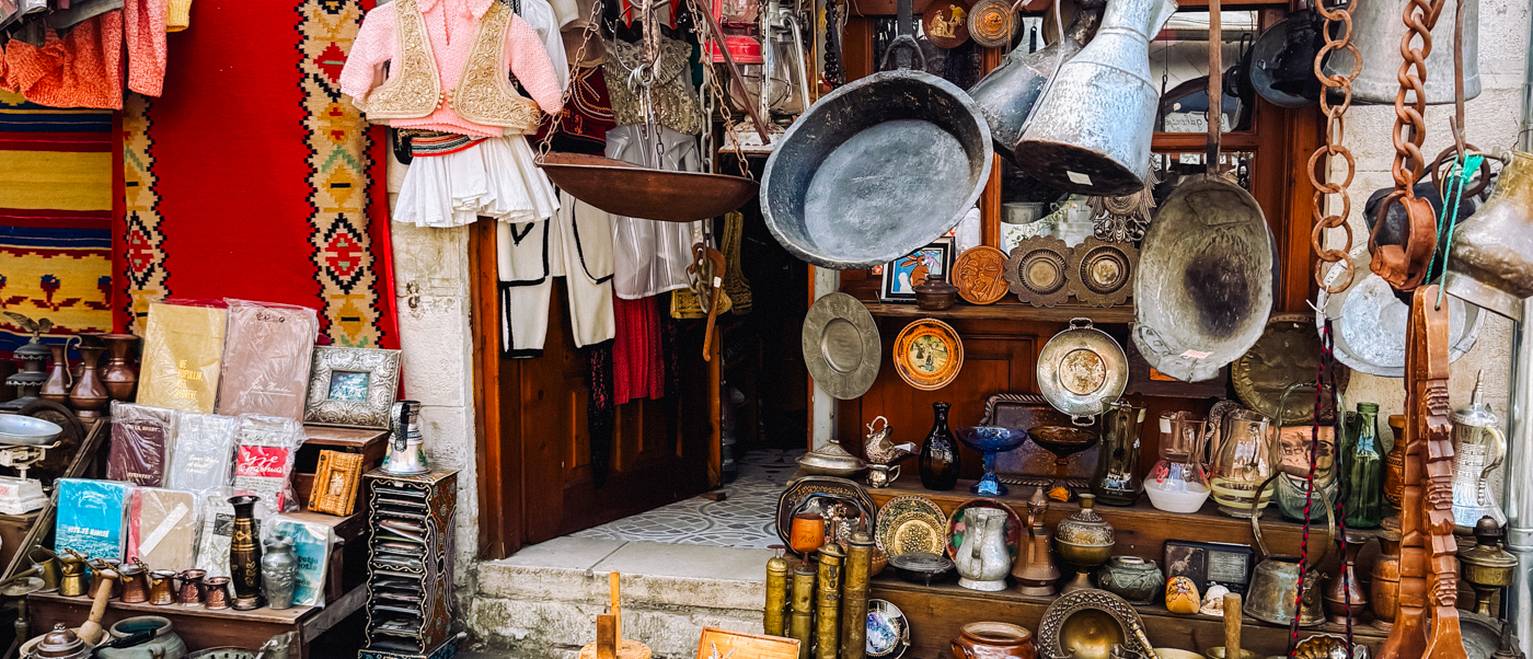A shop in Gjirokastër's old bazaar hung with copper pots, carpets and traditional costumes