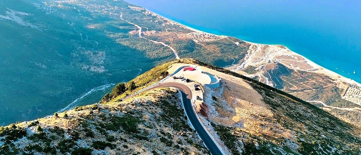 The Llogara Pass road winding over a mountain ridge above the turquoise Ionian coast