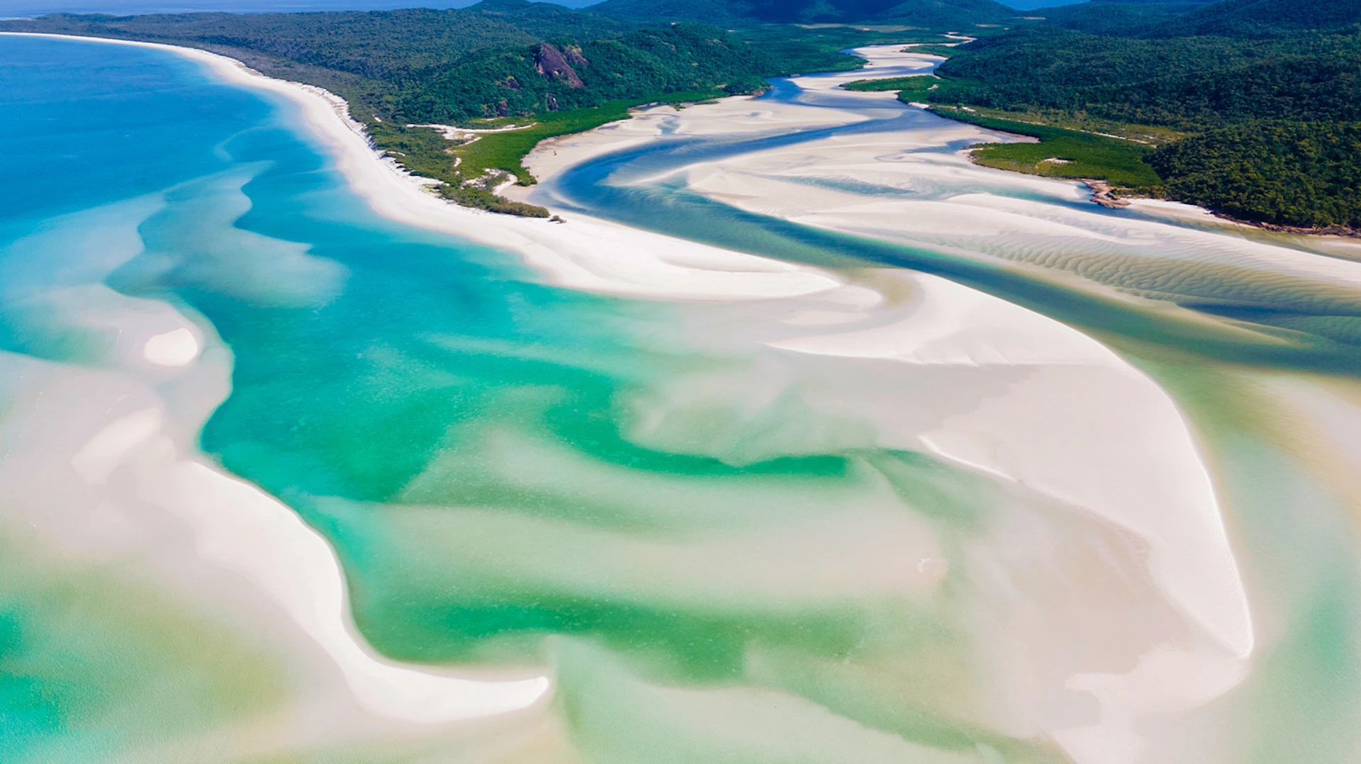 Stunning aerial view of Whitehaven Beach in the Whitsundays with swirling white sands and clear blue waters.