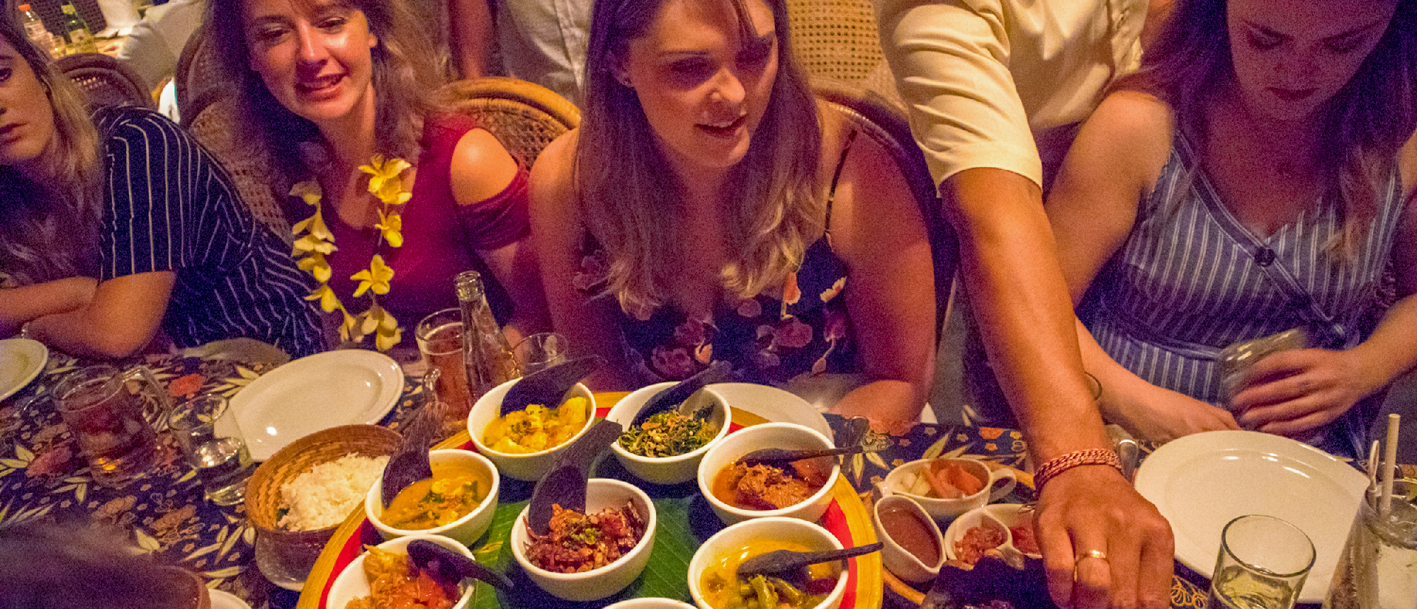 Sharing Balinese food at a long dinner table in Kuta