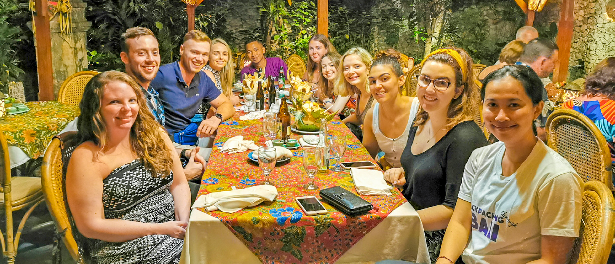 Travelers toasting with cocktails at Bali beach bar