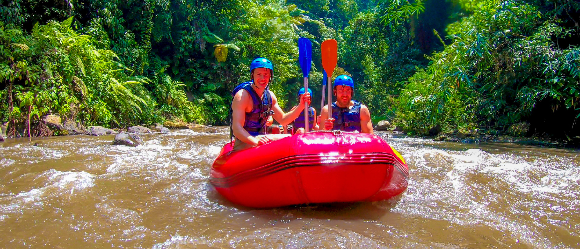 Red raft navigating white-water rapids on Ayung River