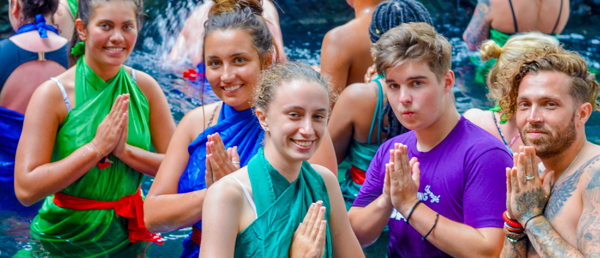 Backpacking group wearing colourful sarongs preparing for a holy water blessing at Pura Tirta Empul