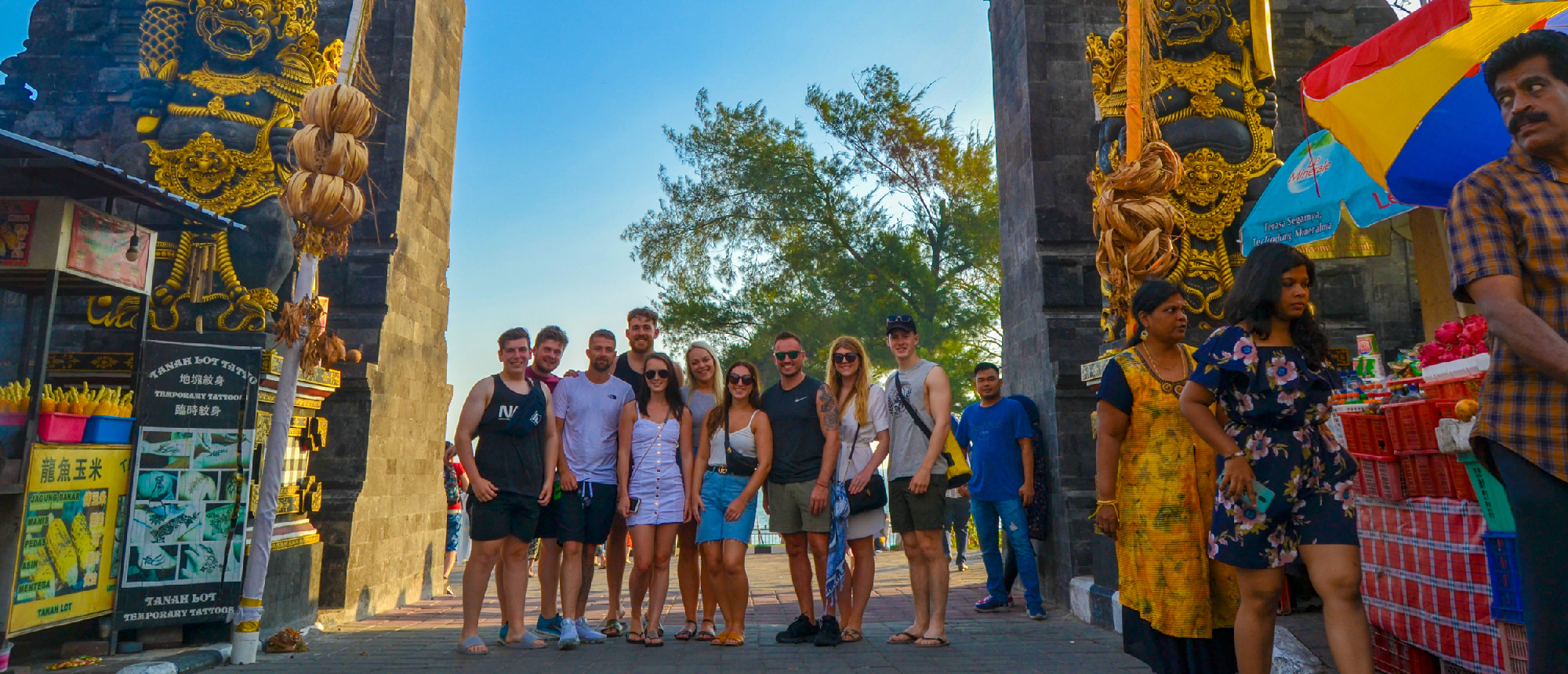 Backpacking group posing at Balinese temple gate