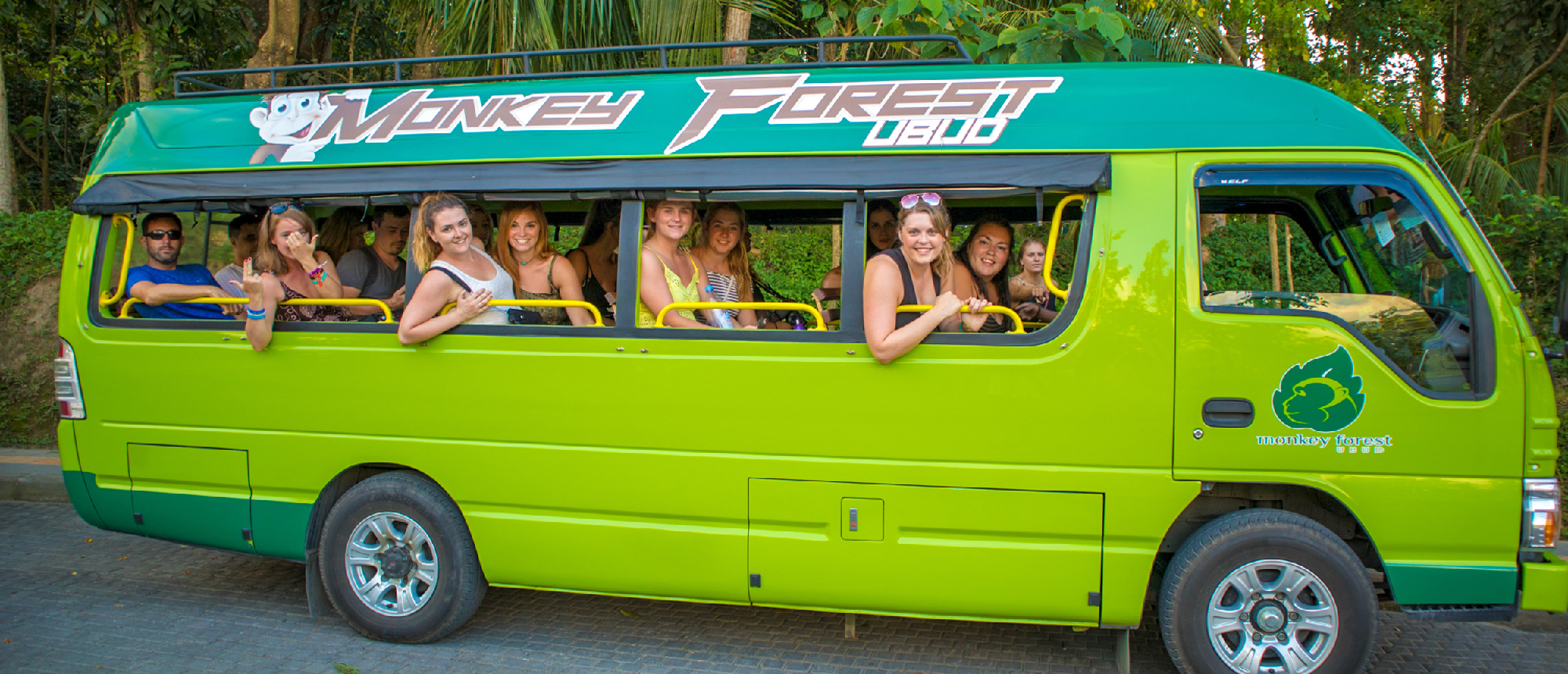 Bright green minibus transporting backpacking group in Ubud