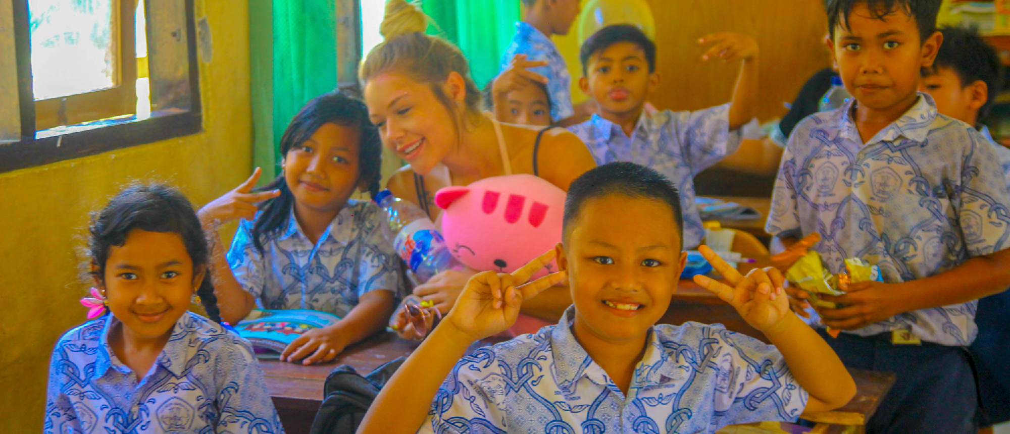 Smiling Balinese school children holding balloons in Ubud