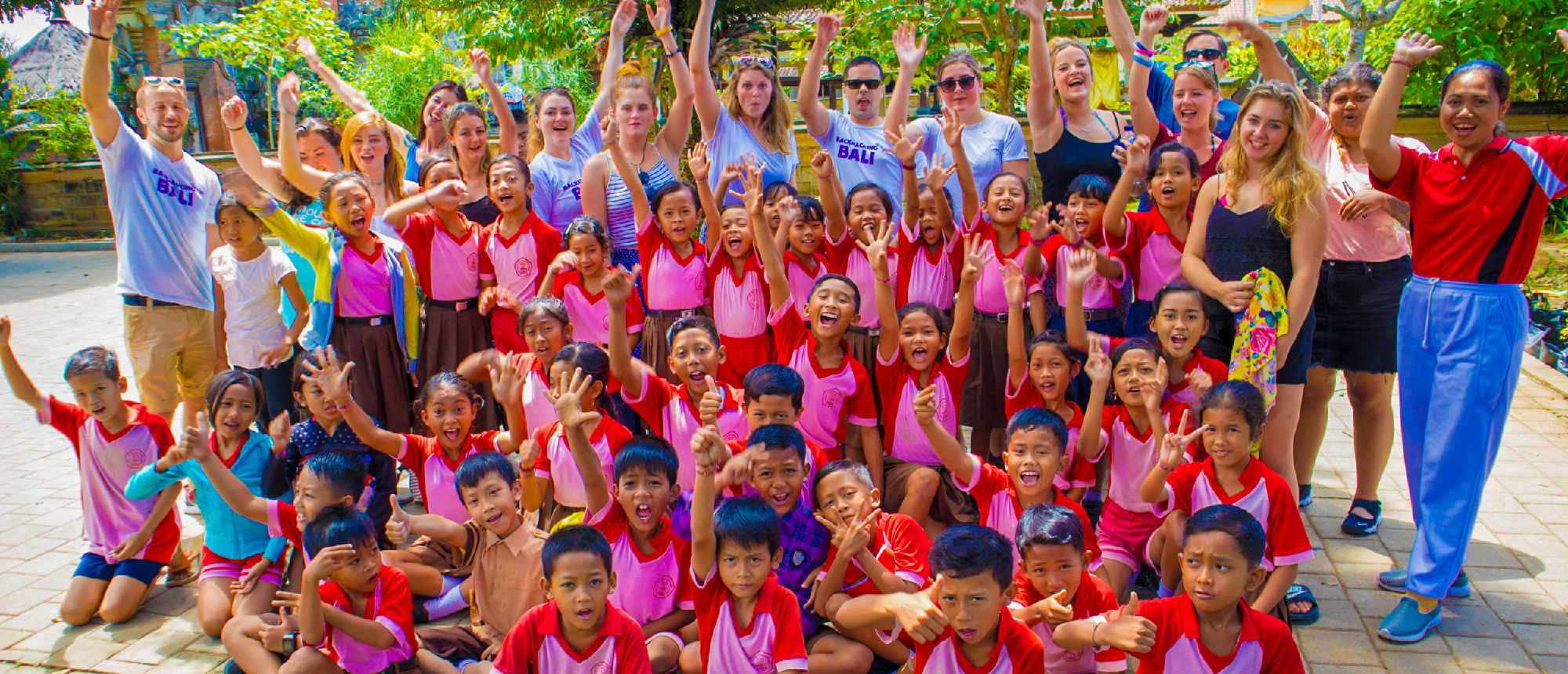 Group photo of backpacking group with local students in Ubud