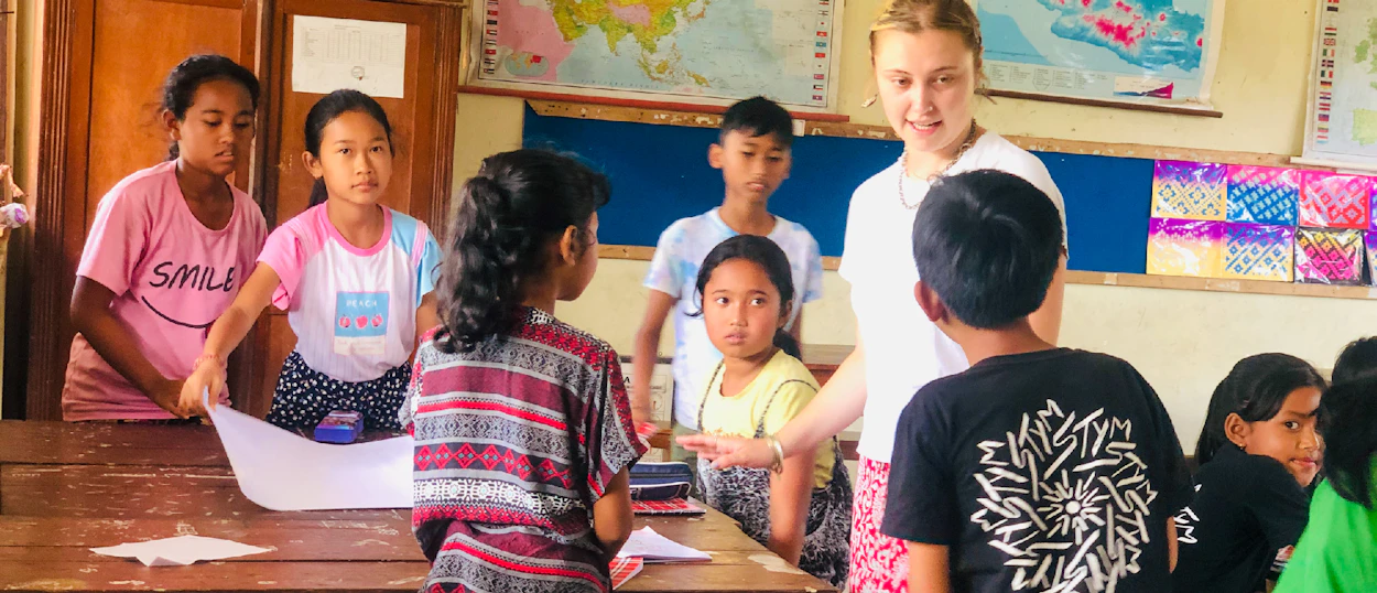 A volunteer leads an environmental education activity with primary school children in a classroom in Bali.