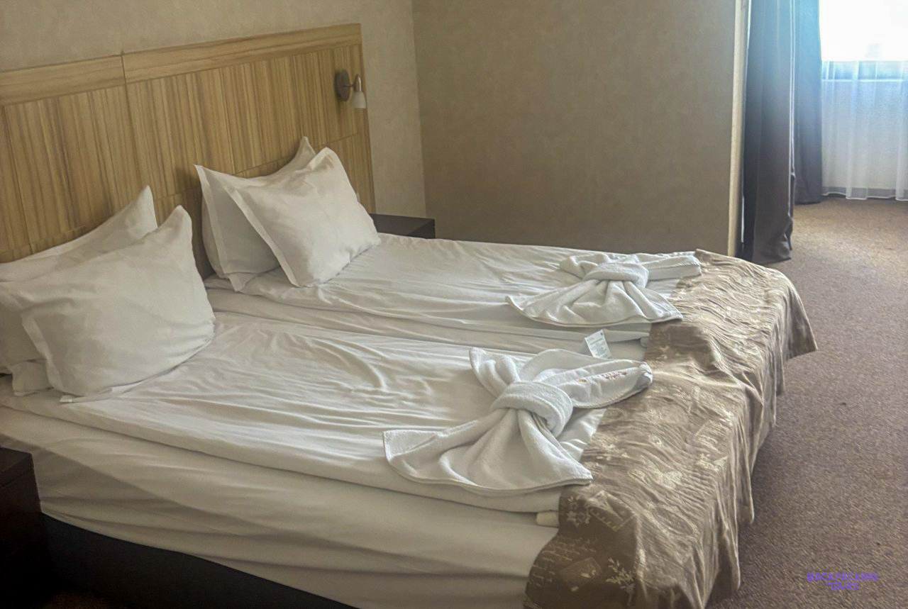 A room with white beds at the hotel in Bansko