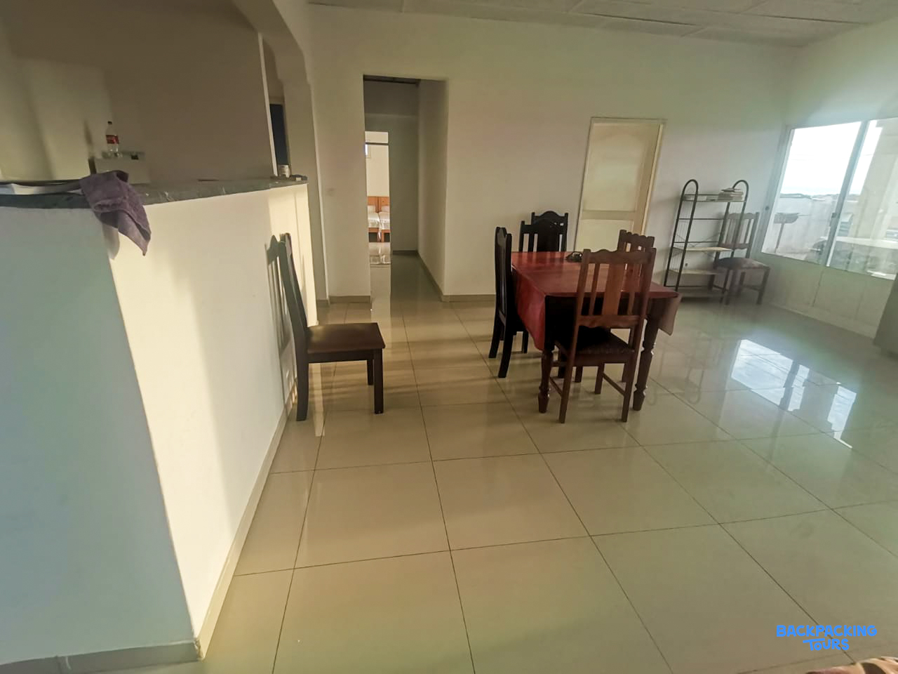 A bright and clean accommodation dining area with a wooden table and chairs.