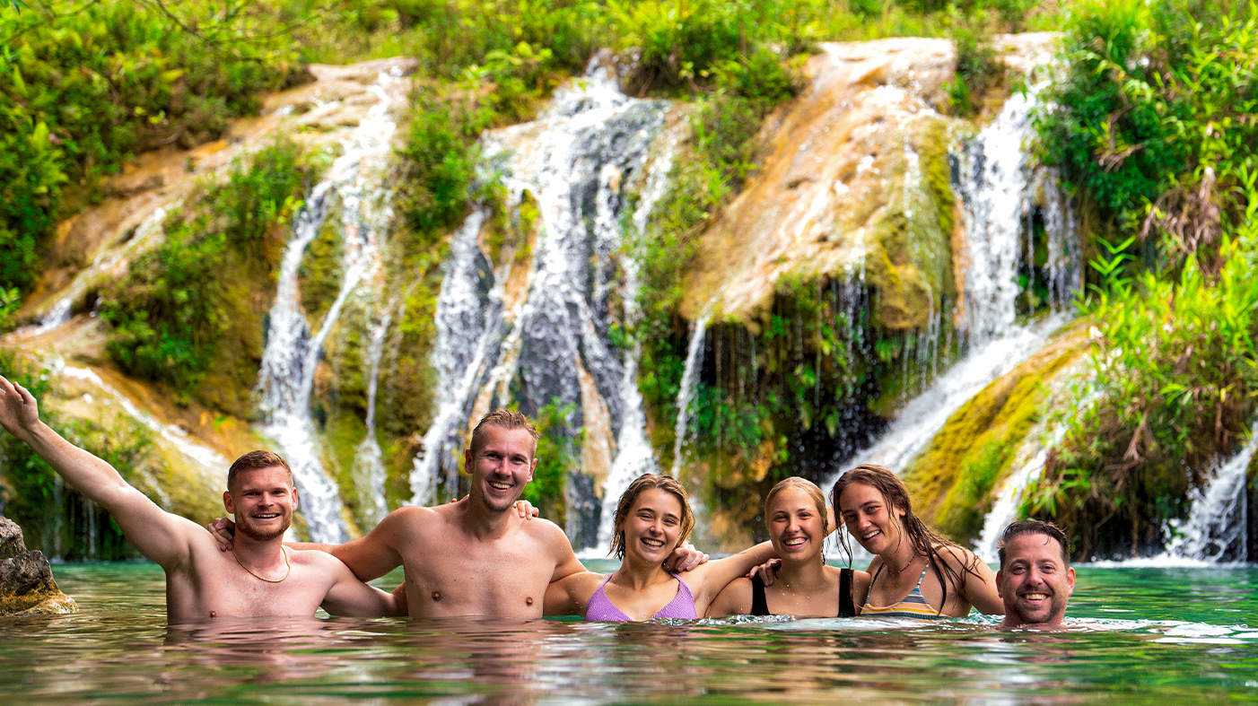 Travellers swimming in the bright turquoise pools of Semuc Champey, Guatemala.