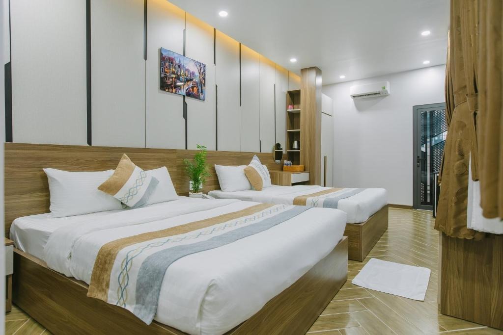 Two double beds with white linen and patterned runners in a bright room with wooden headboards.