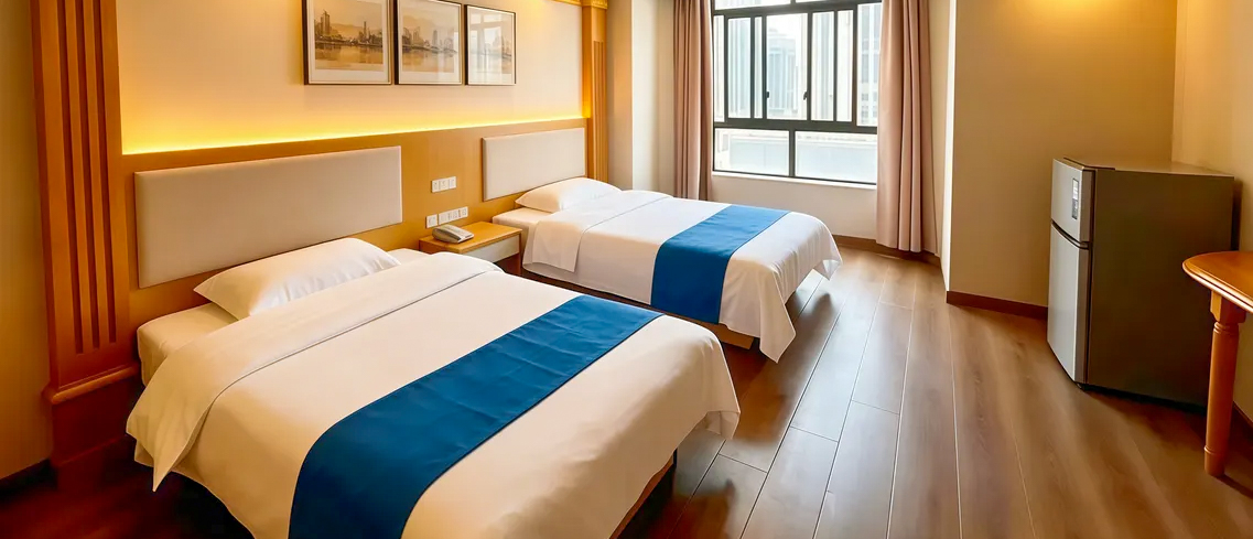 A twin room with two single beds, blue runners, framed prints and a wooden floor.