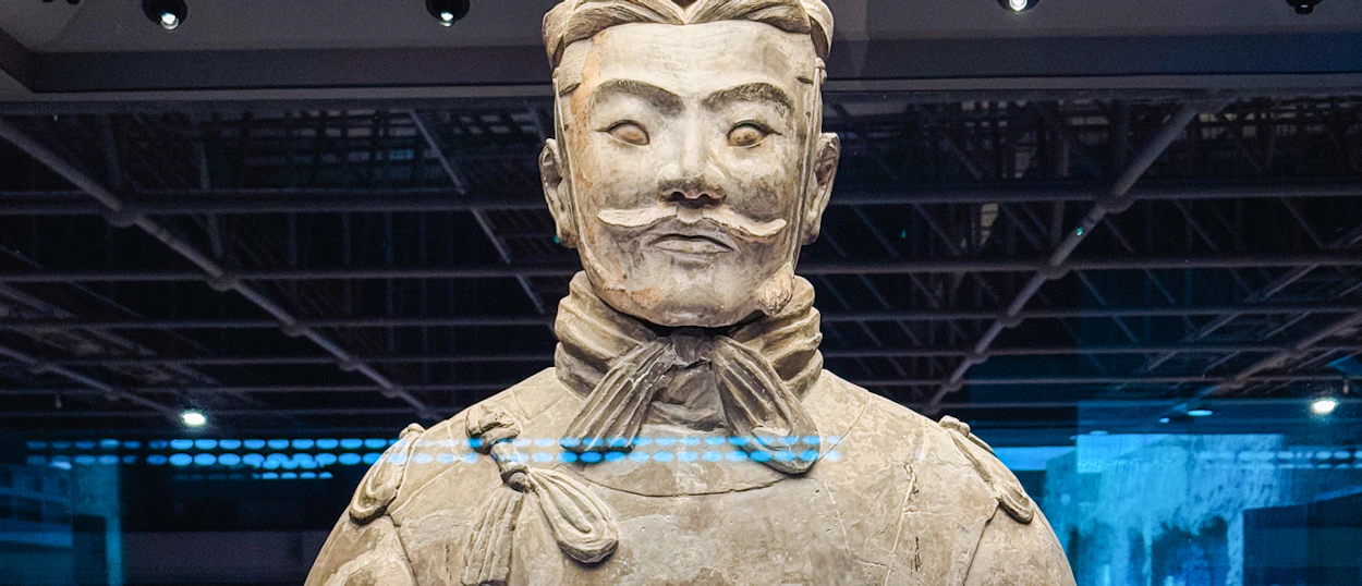 A detailed close-up of a Terracotta Warrior statue, showing its face and armor in Xi'an.
