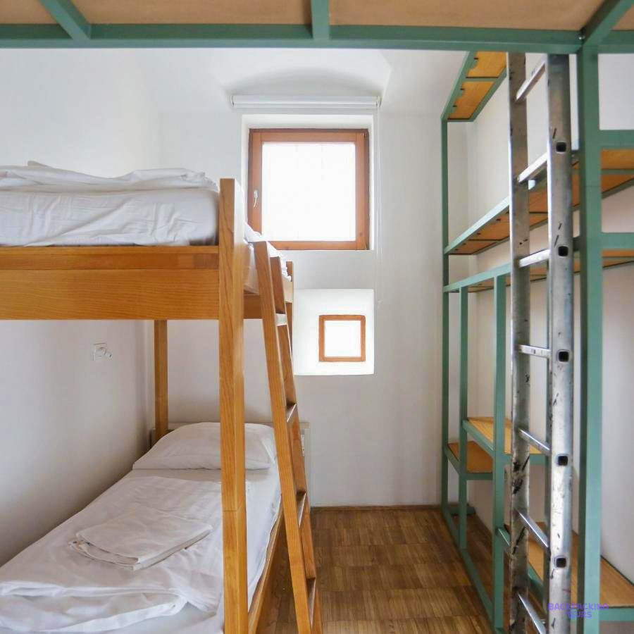 Wooden bunk beds in a white dorm room at the Ljubljana hostel