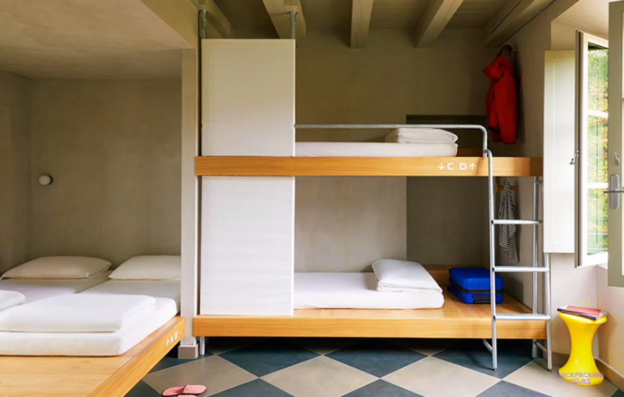A dorm room with wooden bunk beds and a chequered floor at the Milan hostel