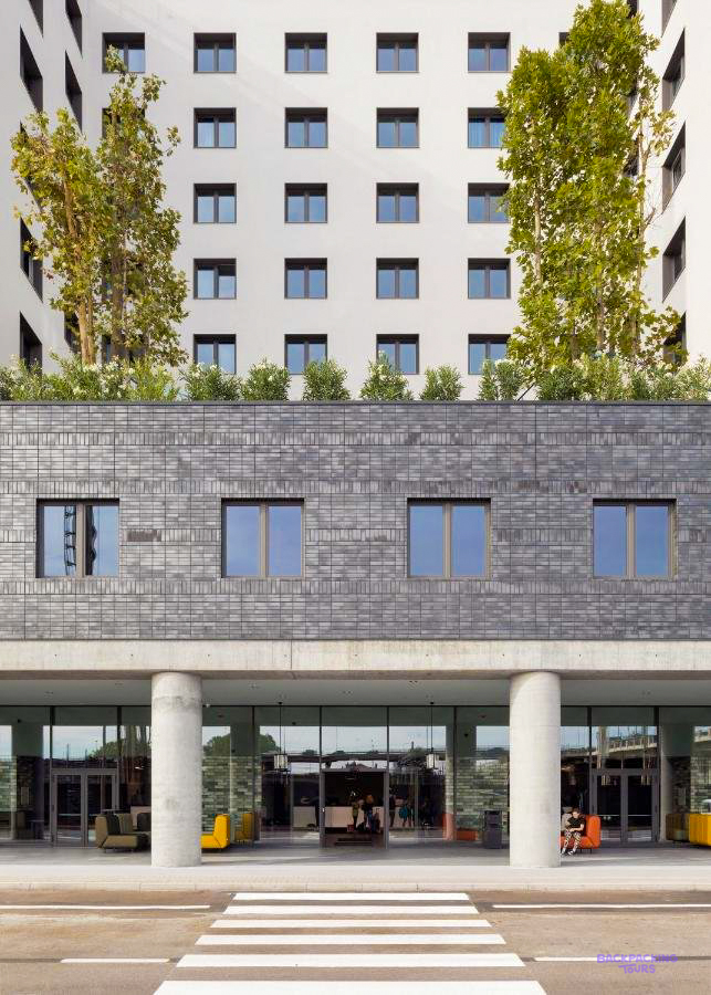 The modern building of the Venice hostel, with trees growing on its terraces