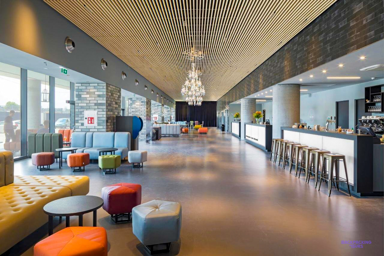 The long lounge and bar of the Venice hostel, with colourful seats and a chandelier