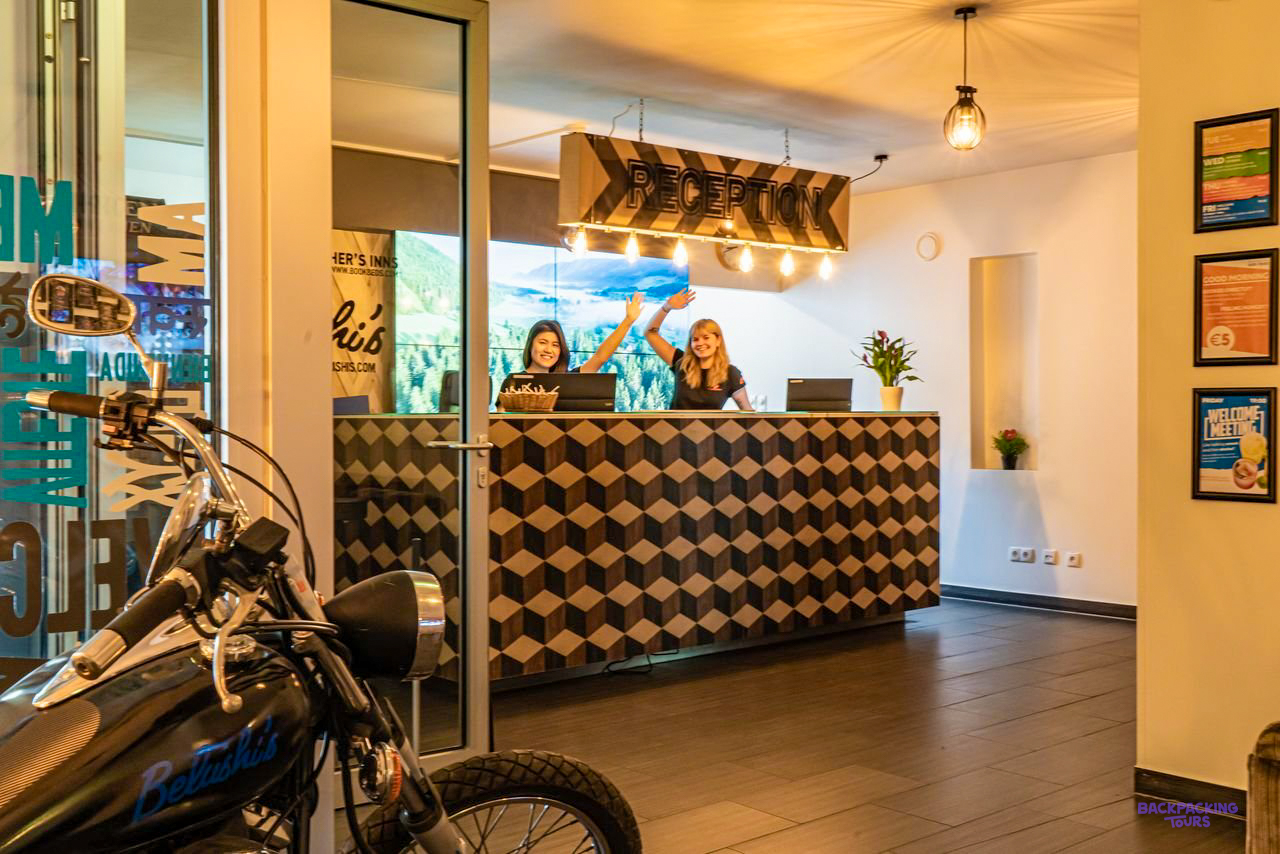 Staff smiling behind the patterned reception desk of the Vienna hostel