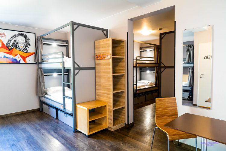 Metal bunk beds with wooden lockers in a dorm room at the Vienna hostel