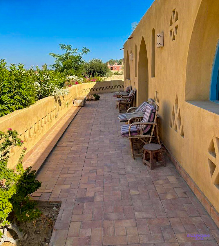 A shaded terrace with loungers along the walls of the lodge in Faiyum