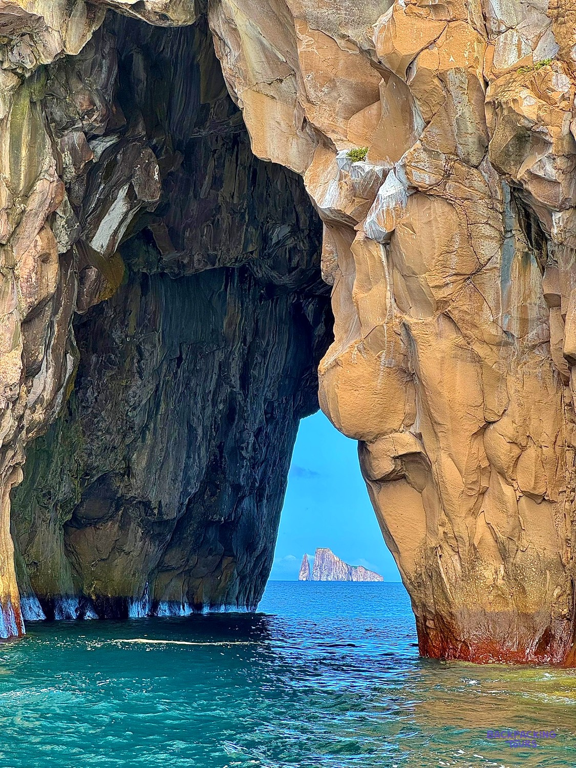 Boat passing through the arch at Kicker Rock