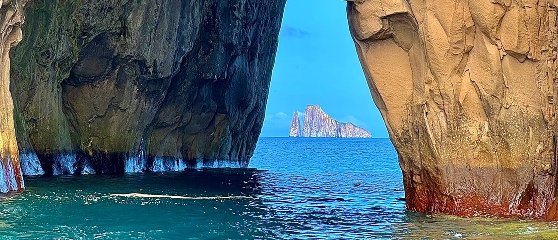 Boat passing through the arch at Kicker Rock