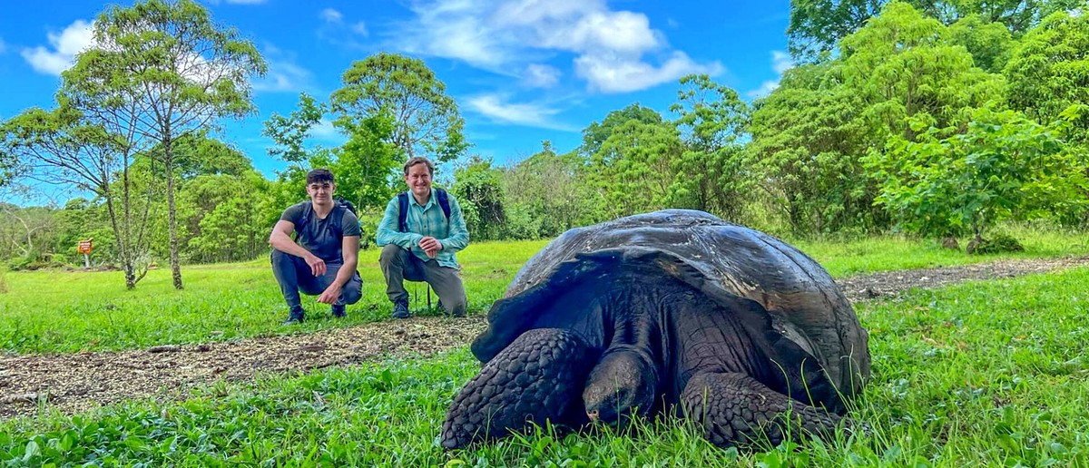 Travellers meeting a giant tortoise in the Santa Cruz highlands