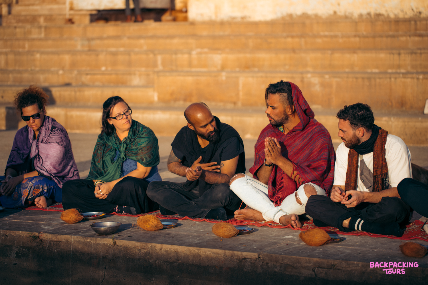 Travelers receiving a traditional Brahmin blessing by the sacred lake in Pushkar, India.
