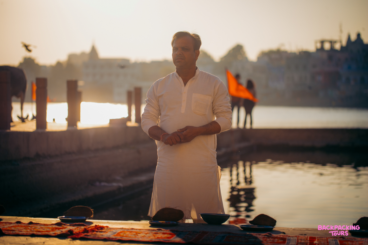 A Brahmin priest performs a traditional blessing ceremony by the sacred Pushkar Lake at sunset.