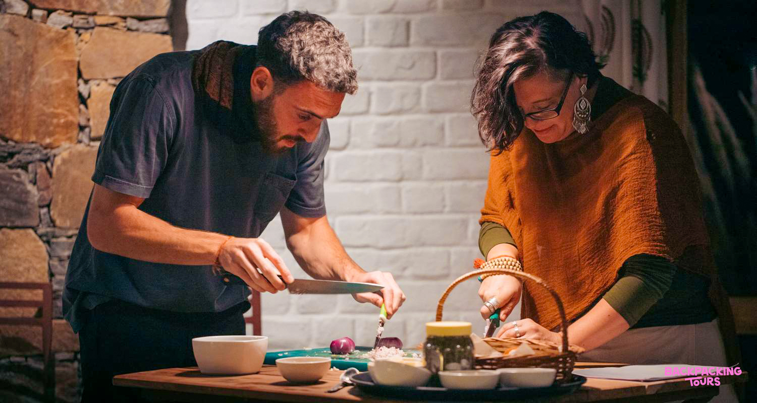 A man and woman focused on chopping ingredients during a fun cooking class in Udaipur.