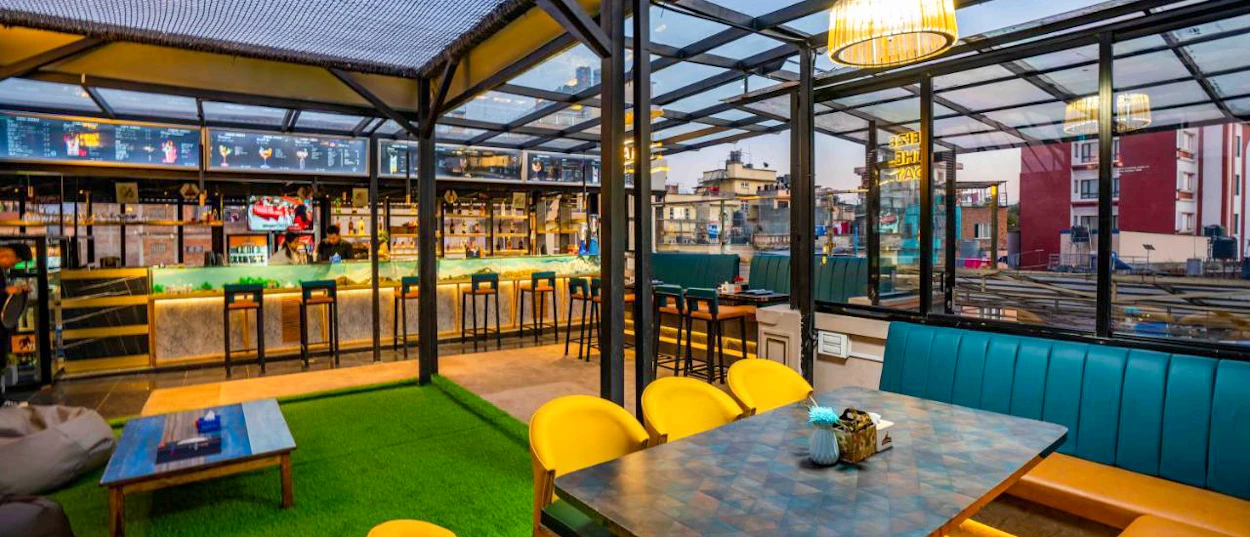 A vibrant, modern rooftop bar and restaurant with colorful seating and city views in Kathmandu.