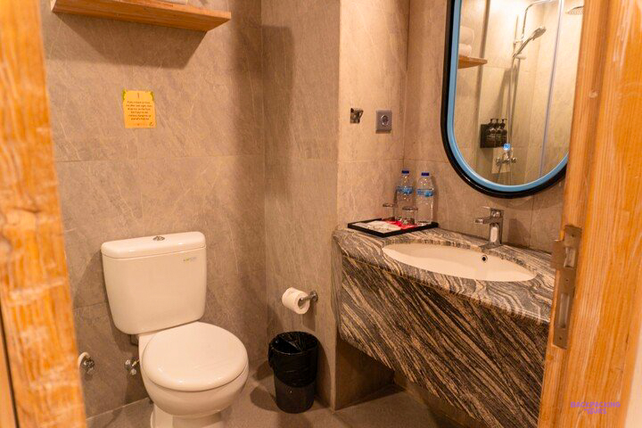 The bathroom at the hotel in Canggu, with a marble basin and a round mirror