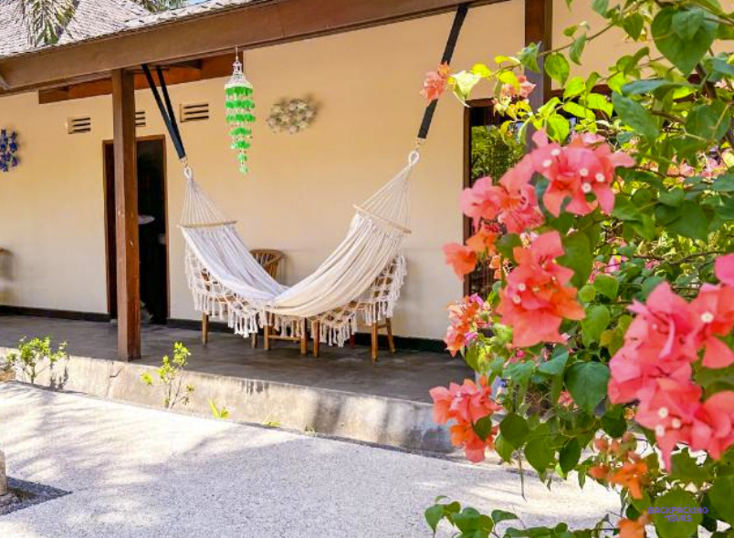 A hammock on the veranda of a room at the Gili Trawangan hotel, framed by pink bougainvillea
