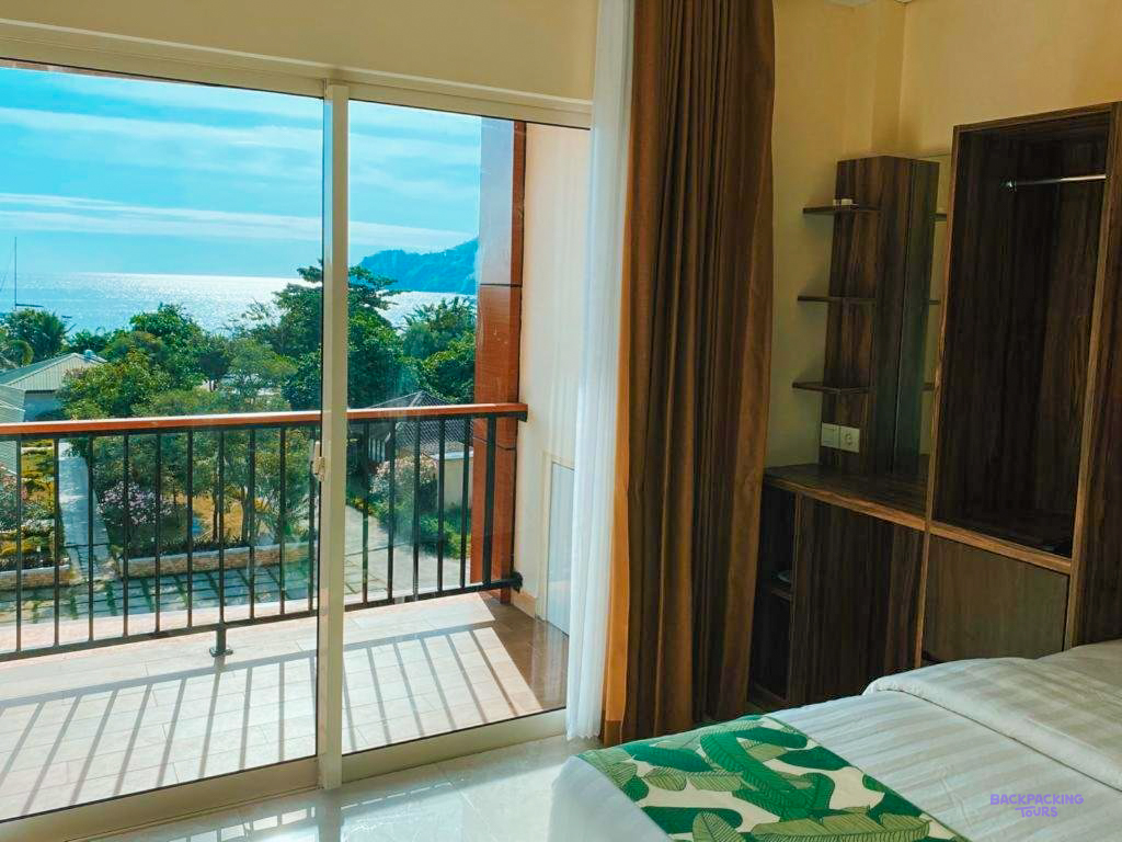 A room with a balcony door open onto the view at the hotel in Labuan Bajo